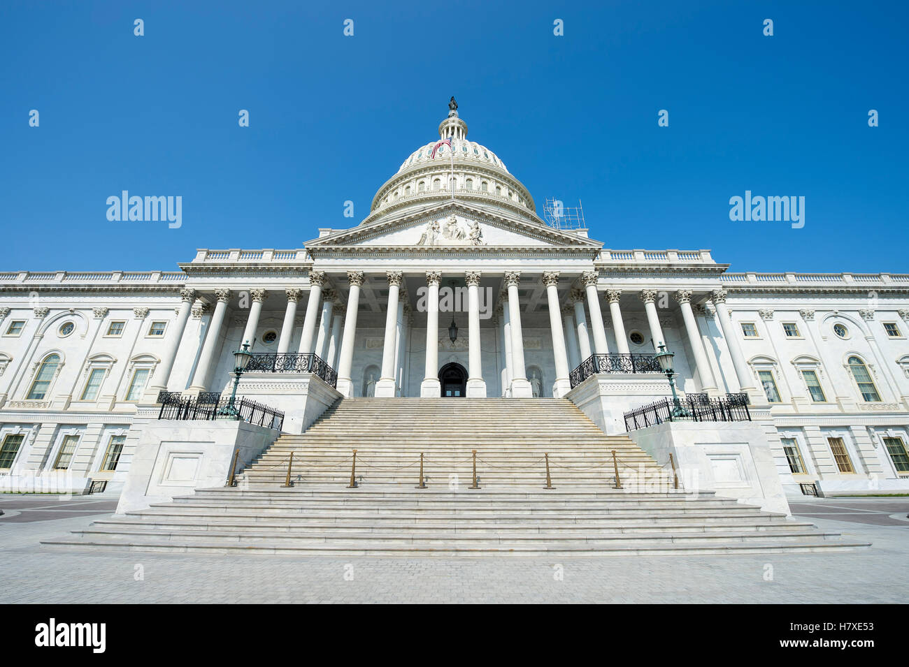 Vista frontale del Campidoglio di Washington DC, Stati Uniti d'America dal davanti della scala d'ingresso sotto il luminoso cielo blu Foto Stock