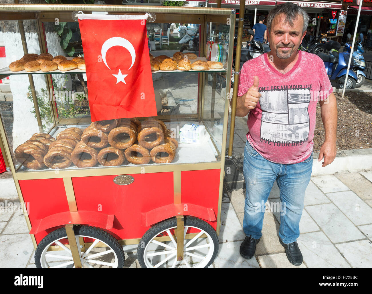 BODRUM, Turchia - 6 ottobre 2016: venditore ambulante sorge accanto alla sua vendita carrello turco tradizionale pane simit. Foto Stock