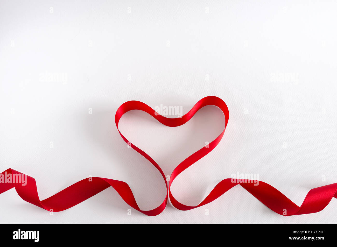 Cuore di San Valentino. Rosso di raso. Isolato su bianco. Il design di confine. Foto Stock