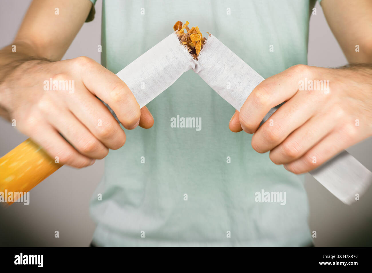 Smettere di fumare - maschio fumatore rottura sigaretta gigante Foto Stock