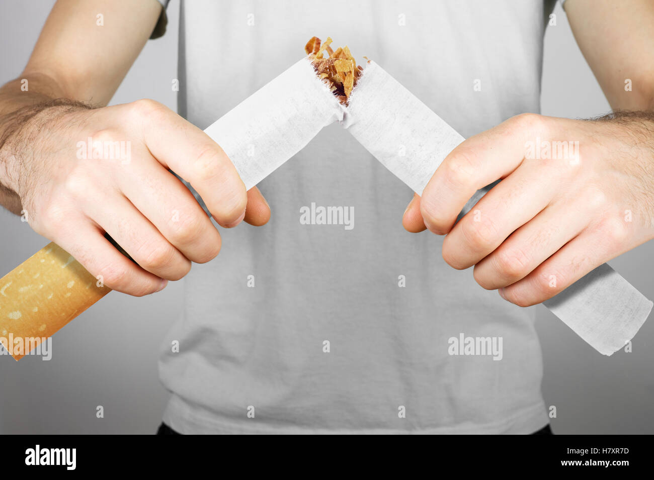 Smettere di fumare - maschio fumatore rottura sigaretta gigante Foto Stock