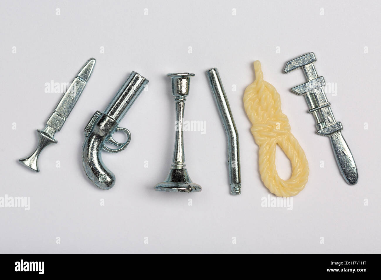 Cluedo gioco di bordo l arma del delitto pezzi (da sinistra a destra) pugnale, pistola, candela stick, barra di ferro, corda, chiave Foto Stock