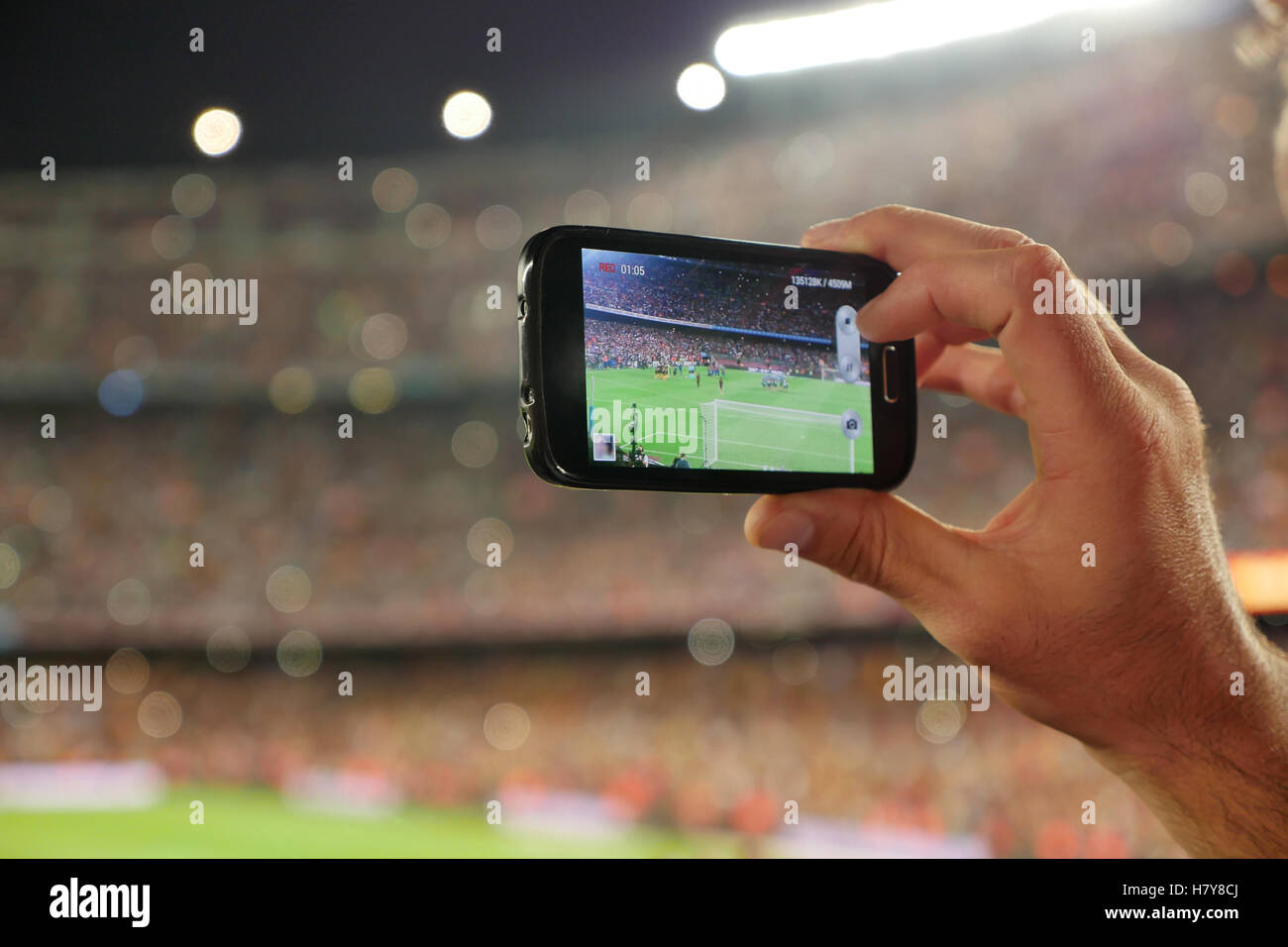 Un sostenitore di F.C. Squadra di calcio, la registrazione di un obiettivo con il suo telefono cellulare Foto Stock