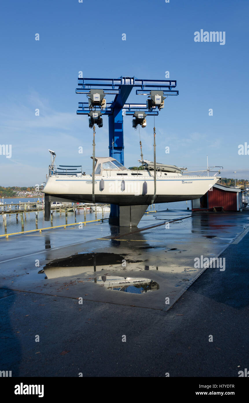 Una grande gru sollevare il sailingboat dall'acqua Foto Stock