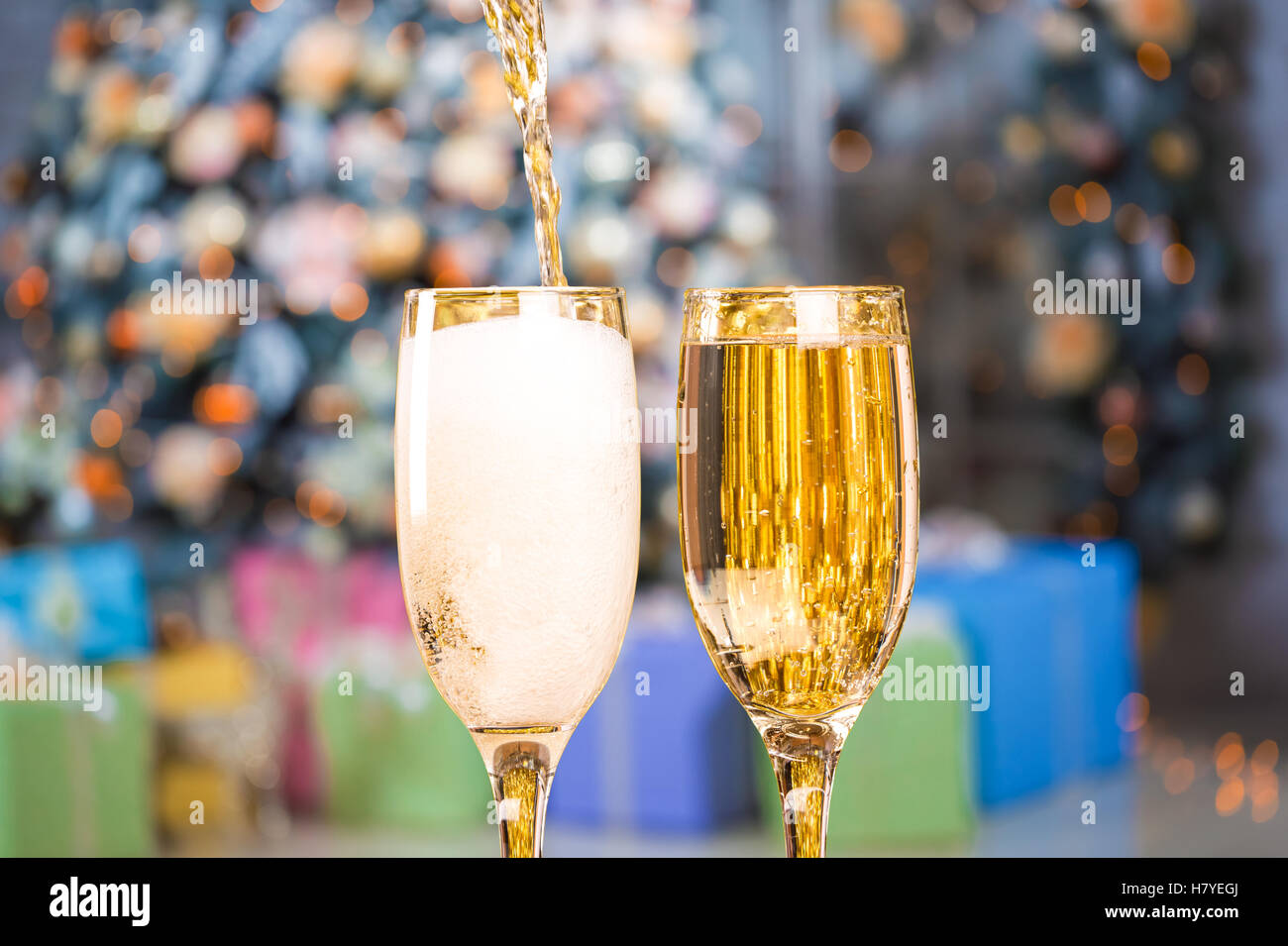 Due bicchieri di champagne su sfondo sfocato natale soggiorno con albero di natale Foto Stock
