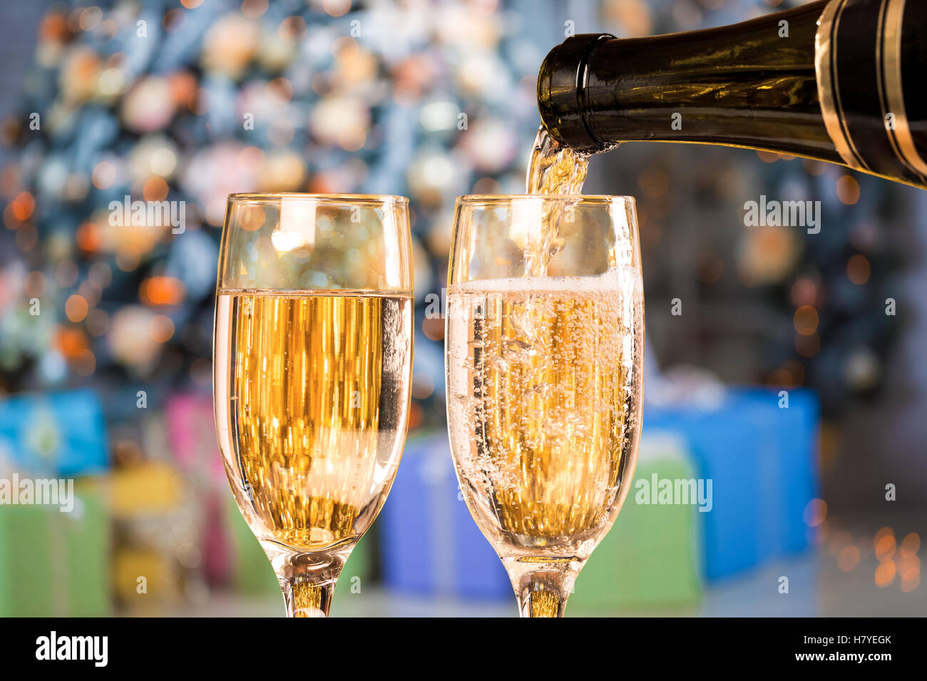 Due bicchieri di champagne su sfondo sfocato natale soggiorno con albero di natale Foto Stock