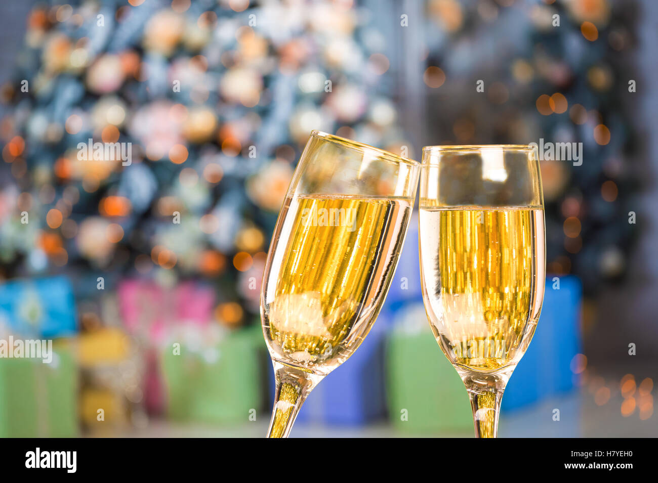 Due bicchieri di champagne su sfondo sfocato natale soggiorno con albero di natale Foto Stock