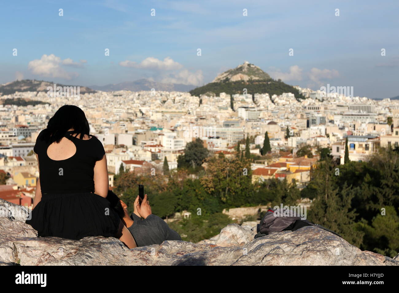 Un giovane si gode della vista dal areopago o Areios Pagos, affacciata su Lykavittos Hill, a Atene, Grecia Foto Stock
