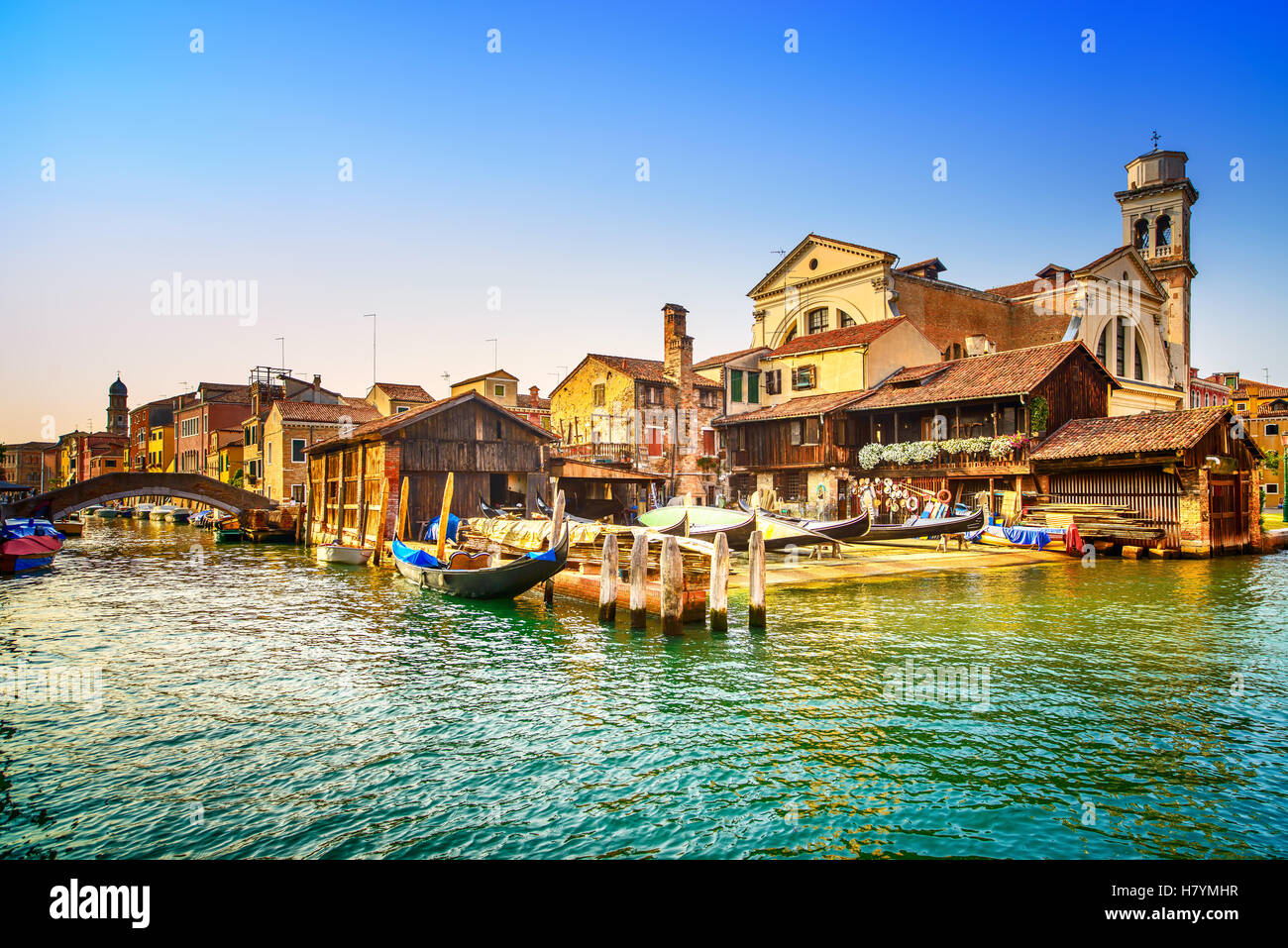 Venezia, acqua canal, bridge e gondole o gondole depot il tramonto. L'Italia, l'Europa. Foto Stock