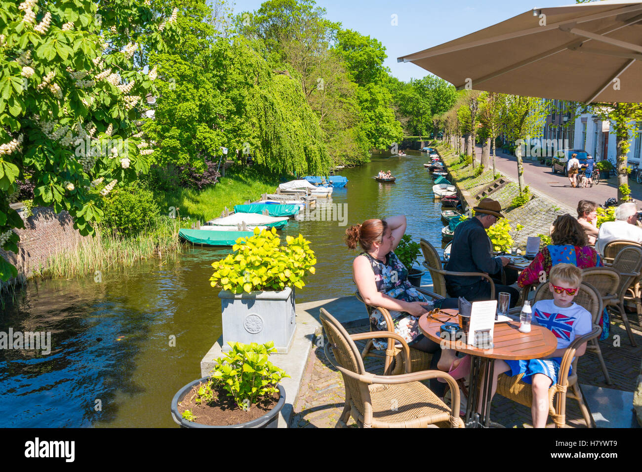 Le persone sulla terrazza fronte mare di cafe e il canale con le barche nella città vecchia di Naarden, Olanda Settentrionale, Paesi Bassi Foto Stock
