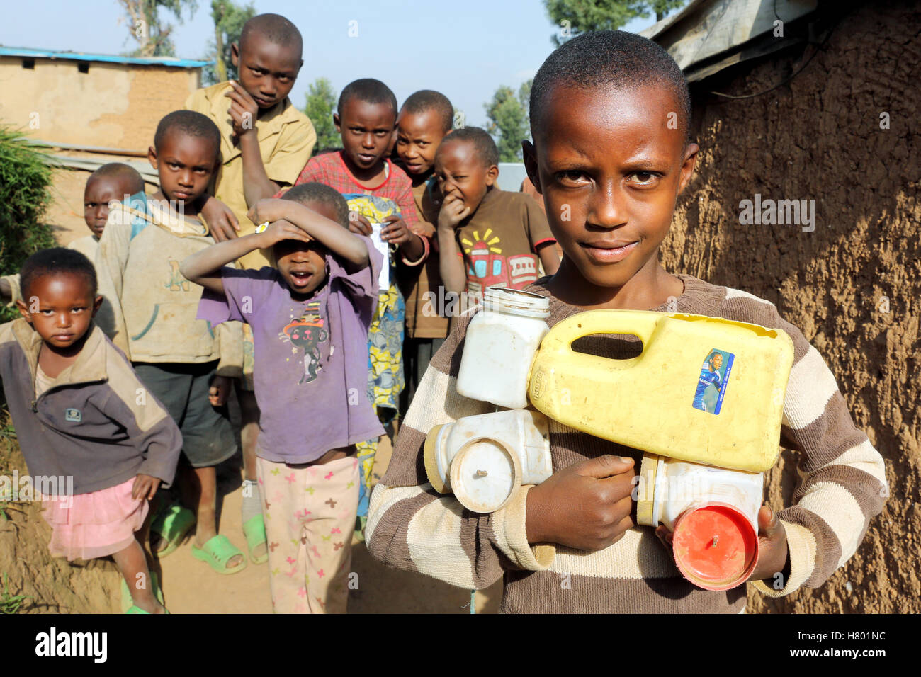 I bambini rifugiati dalla Repubblica Democratica del Congo nell'UNHCR Kigeme Refugee Camp con self-made auto giocattolo di lattine in plastica. Diocesi di Gikongoro, in Rwanda, Africa Foto Stock