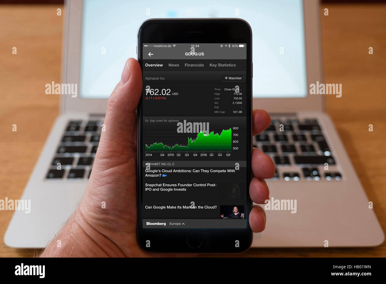 Utilizzo di iPhone smartphone per visualizzare il mercato azionario grafico delle prestazioni per Google società alfabeto Foto Stock