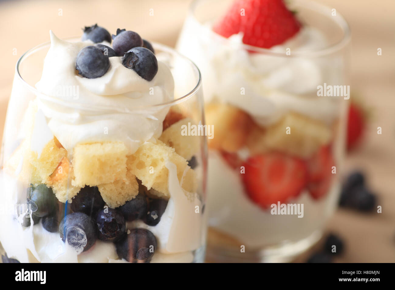 Occhiali con fresco e Mirtillo Fragola trifles con torta e panna montata Foto Stock