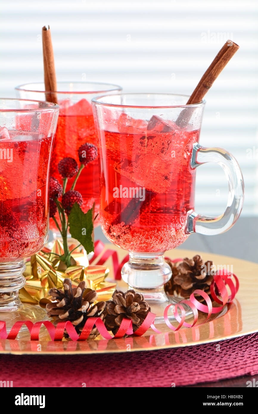 Festive rosso frizzante di soda di mirtillo palustre di bevande con cannella agitare bastoni in rosso e oro accenti a tema. Profondità di campo Foto Stock