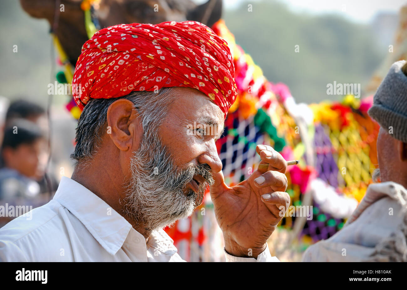 Ritratto di un fumo non identificato di Rajasthani uomo indiano partecipa alla fiera di Pushkar, India Foto Stock
