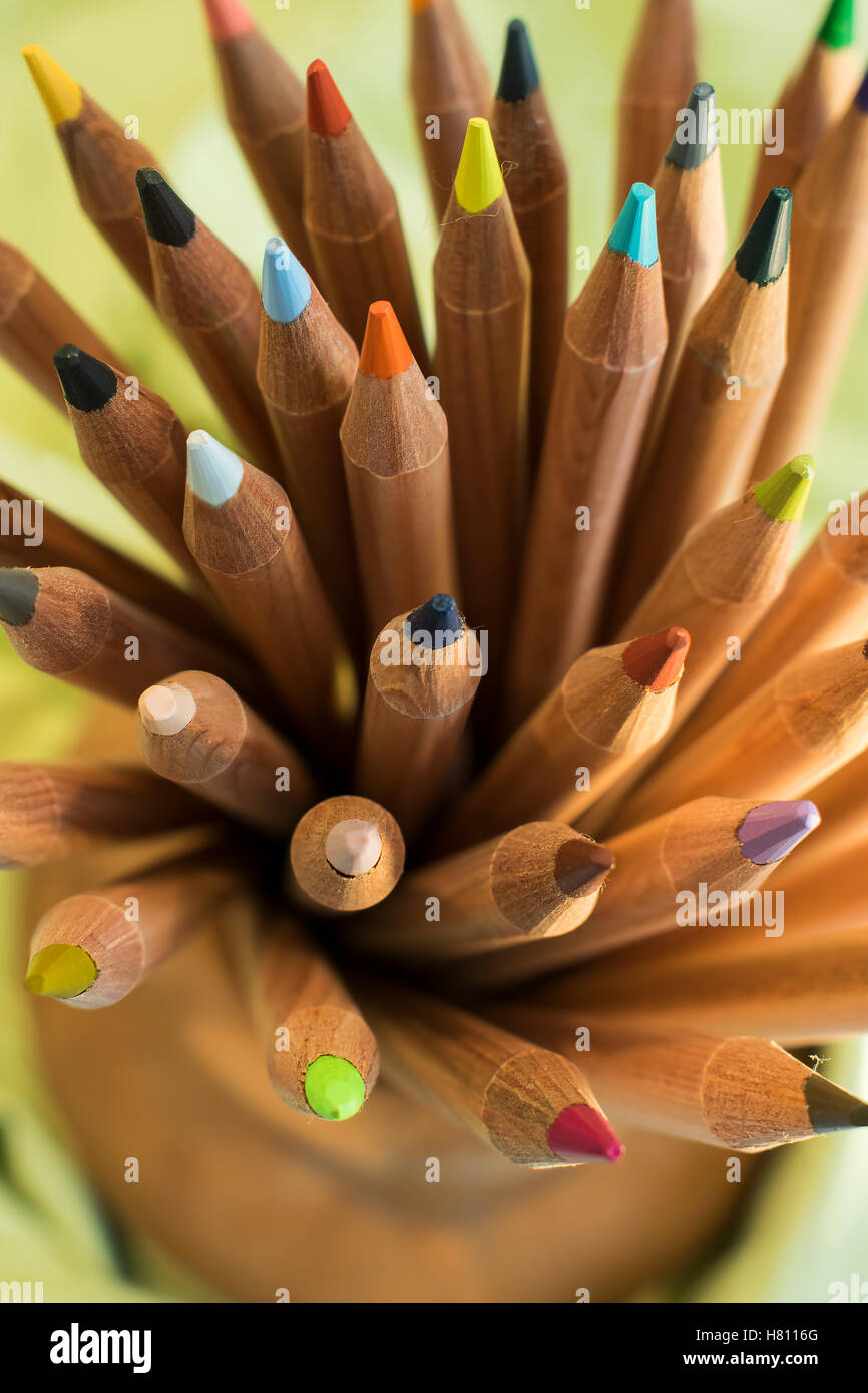 Mazzetto di legno matite di colore poste in vaso di ceramica titolare Foto Stock