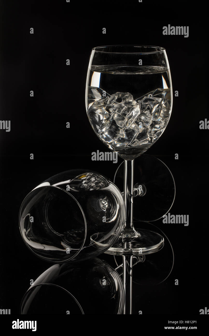 Wineglasses su un vetro nero di sfondo per studio Foto Stock