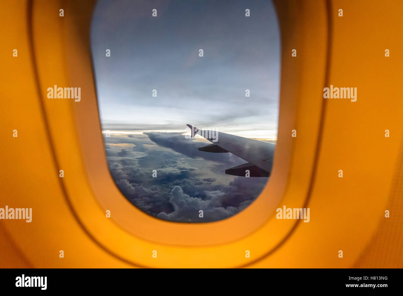 Ala di aeromobile su nuvole, battenti la sera lo sfondo della finestra. Foto Stock