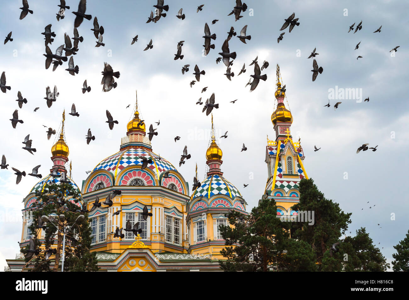 Piccioni volando sopra la cattedrale di ascensione o Cattedrale Zenkov, Panfilov Park, Almaty in Kazakistan e in Asia centrale Foto Stock