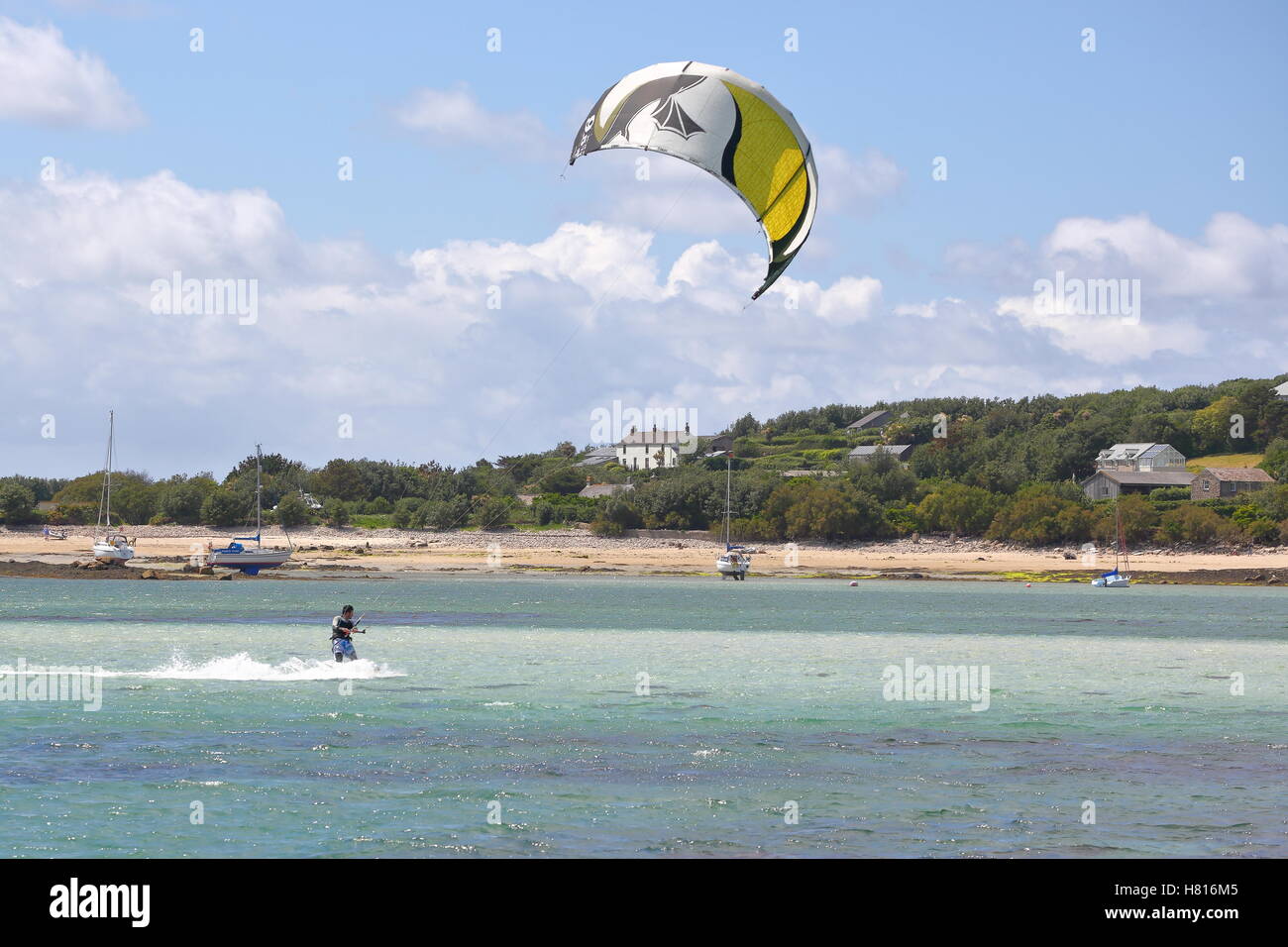Un kite surfer cavalcare le onde su isole Scilly Foto Stock