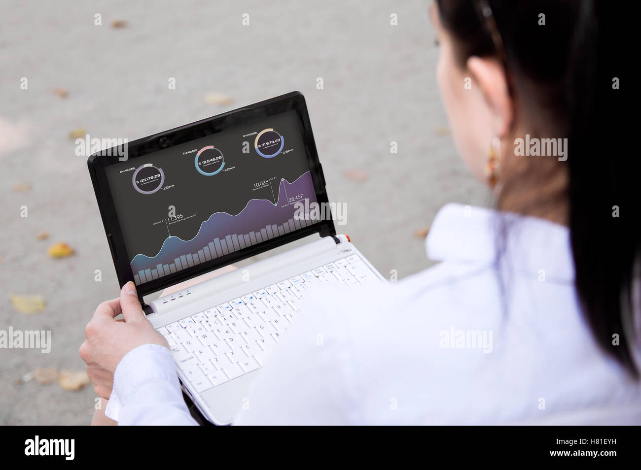 Imprenditrice controlli di analisi delle finanze sul proprio portatile all'aperto Foto Stock