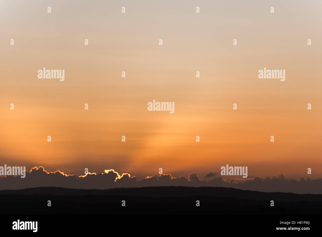 Raggi di sole appaiono da dietro le nuvole come il sole sorge in una fredda mattina di autunno. Foto Stock
