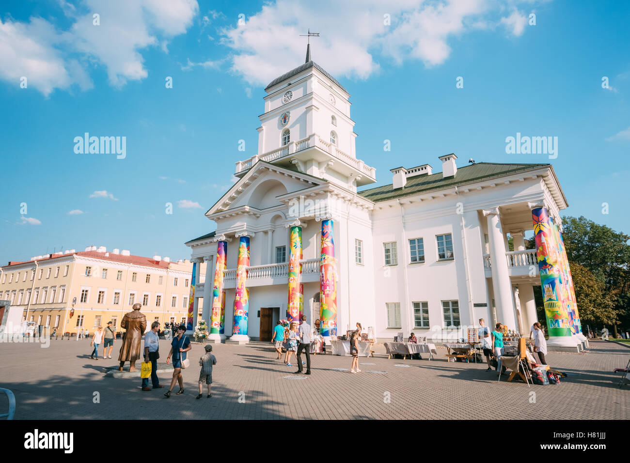 Minsk, Bielorussia. La gente che camminava sulla piazza della Libertà accanto a un edificio bianco di Minsk Town Hall, monumento storico del classicismo in Foto Stock