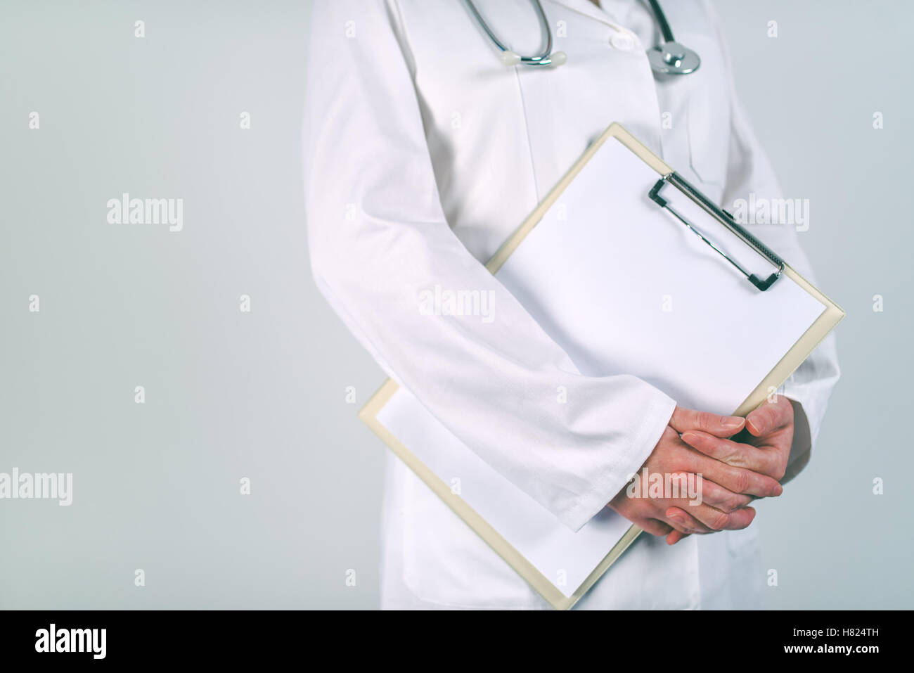 Medico donna in bianco uniforme in posa con vuoto pad appunti come copia di spazio per il testo o del paziente storia medica. La donna come hea Foto Stock