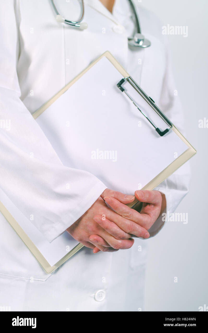 Medico donna in bianco uniforme in posa con vuoto pad appunti come copia di spazio per il testo o del paziente storia medica Foto Stock