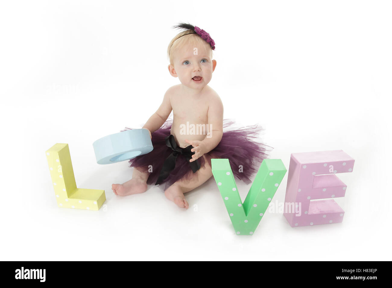 Baby girl in viola tutu con un gioco di parole di amore, studio di fotografia fotografia Foto Stock