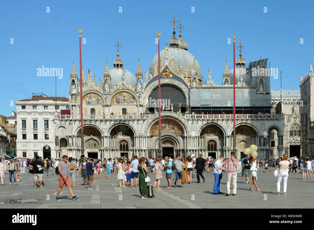 Turisti in Piazza San Marco di fronte alla Basilica di San Marco di Venezia in Italia. Foto Stock