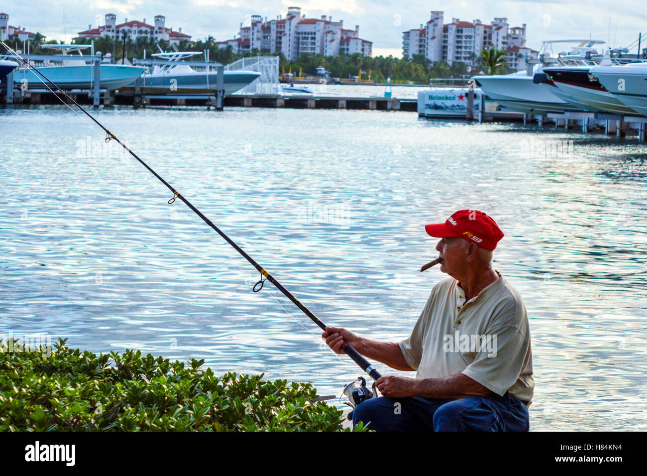 Miami Beach Florida, Biscayne Bay, uomo ispanico uomini maschi, fumatori sigaro, pesca, FL160925123 Foto Stock