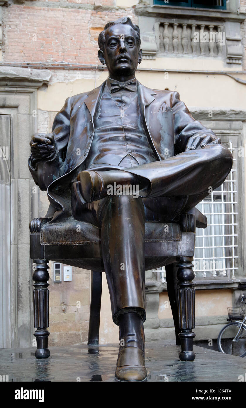 Statua in bronzo di Giacomo Puccini seduto in una sedia confortevole in Corte San Lorenzo, Lucca, Italia. Foto Stock