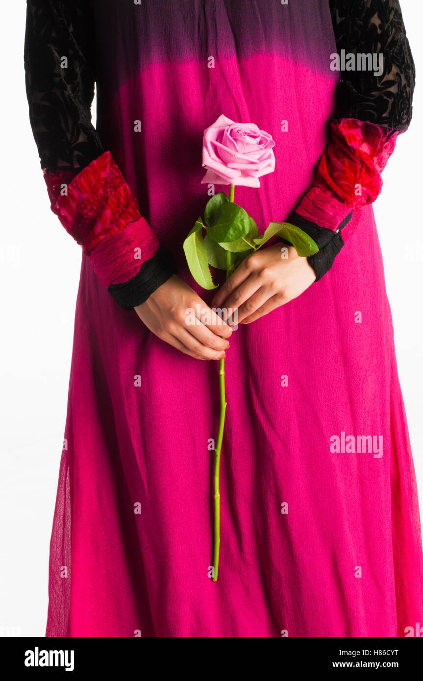 Close up della donna asiatica tenendo un rosa rosa Foto Stock