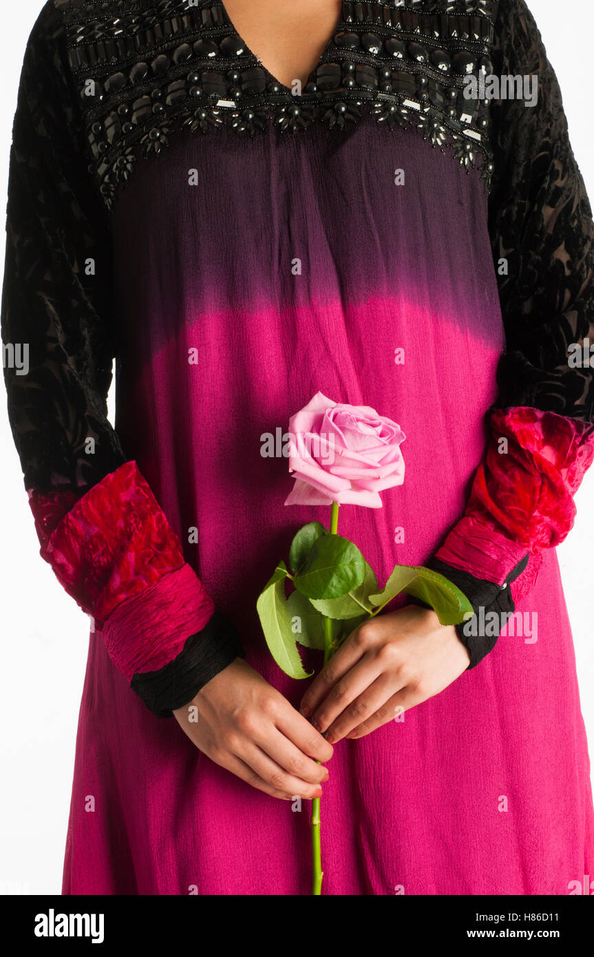 Close up della donna asiatica tenendo un rosa rosa Foto Stock
