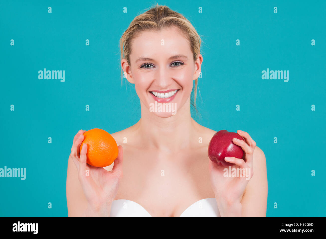 Bella donna azienda apple e orange sorridente Foto Stock