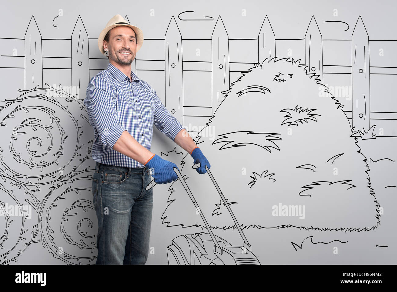 Felice agricoltore mediante taglio di erba. Foto Stock