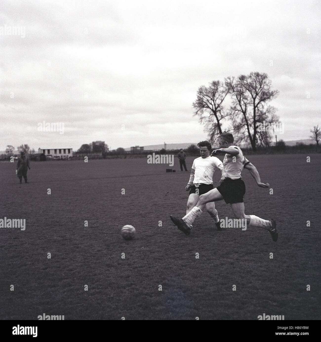 1965, storico dilettante partita di calcio, due maschi i giocatori in competizione per la palla, Bucks, Inghilterra. Foto Stock