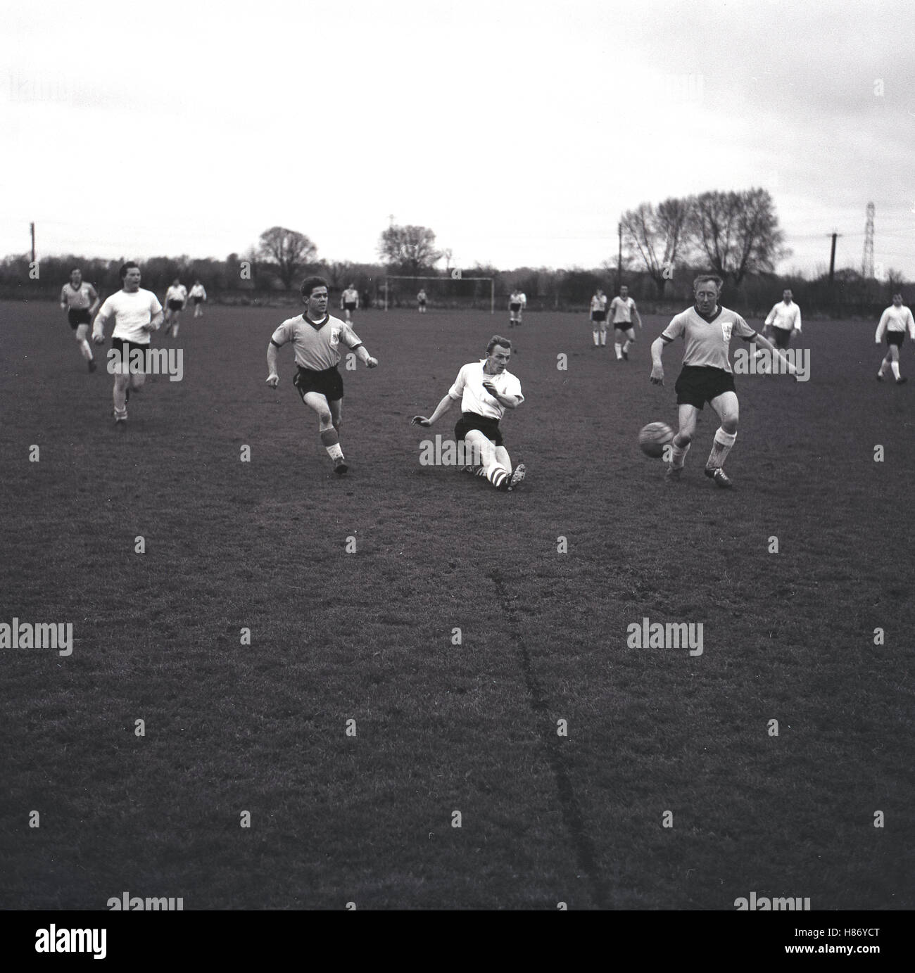 1965, storico dilettante partita di calcio, un riscontro in una camicia bianca spara per obiettivo, Bucks, Inghilterra. Foto Stock