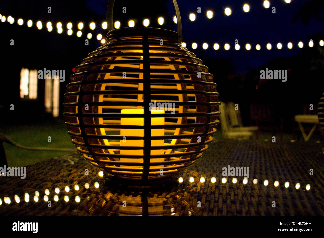 Tarda serata estiva in un giardino inglese con luci decorative Foto Stock