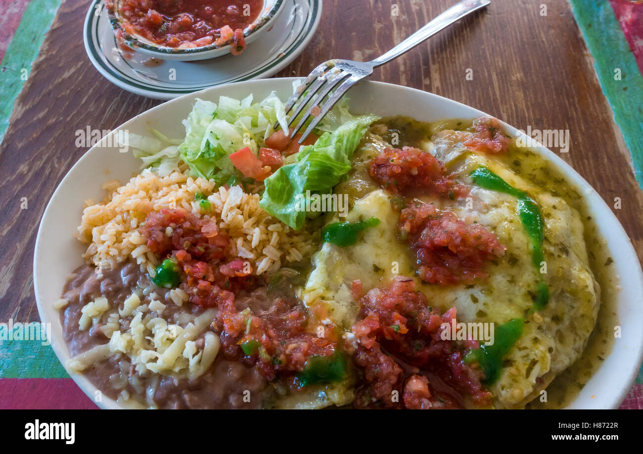 Chicken enchiladas con refried fagioli, riso e insalata con salsa fresca e salsa piccante Foto Stock