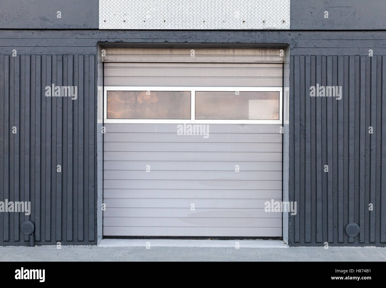 Il cancello chiuso in metallo grigio parete magazzino, sfondo piatto texture foto Foto Stock