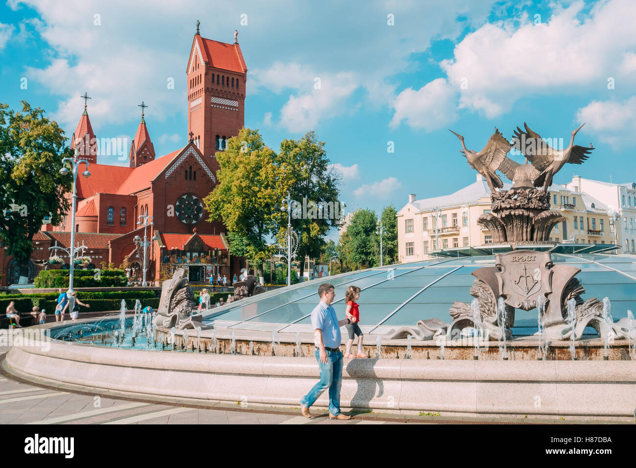 Bielorussia Minsk. Piazza Indipendenza, metà uomo adulto che conduce la sua figlia di età elementari per mano vicino alla cupola di vetro con Fo Foto Stock