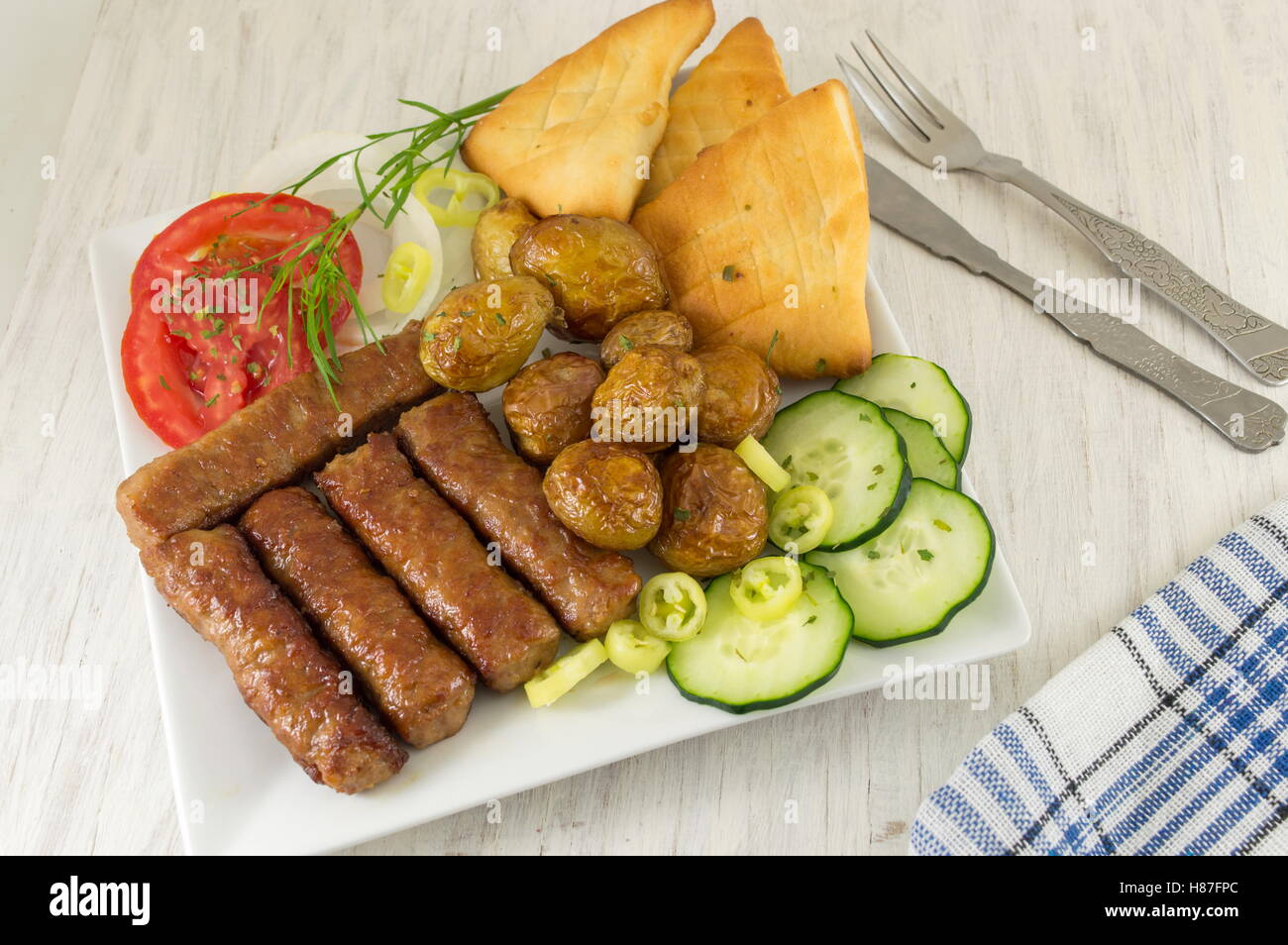 Barbecue su una piastra con pane e verdure Foto Stock