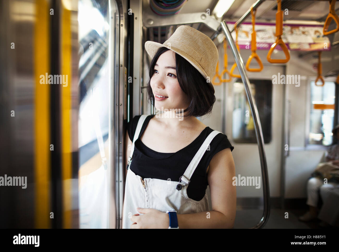 Giovane donna che indossa un cappello a bordo di un treno. Foto Stock