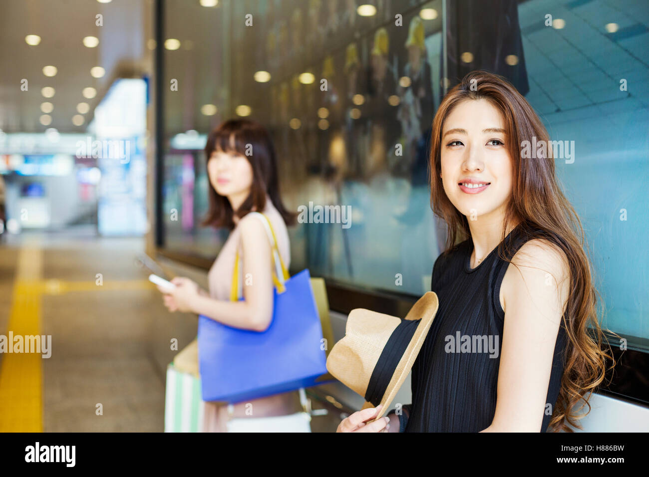 Due giovani donne con capelli lunghi marrone in un centro commerciale. Foto Stock