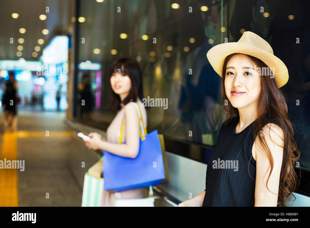 Due giovani donne con capelli lunghi marrone in un centro commerciale. Foto Stock