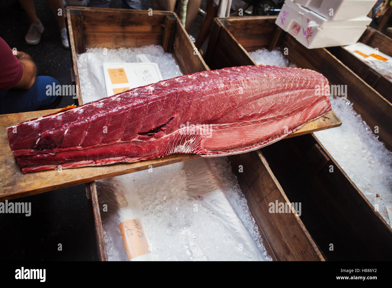 Un tradizionale mercato del pesce fresco in Tokyo. Un grande filetto di tonno su una tavola di legno. pescato del giorno cucina tradizionale scelta Foto Stock