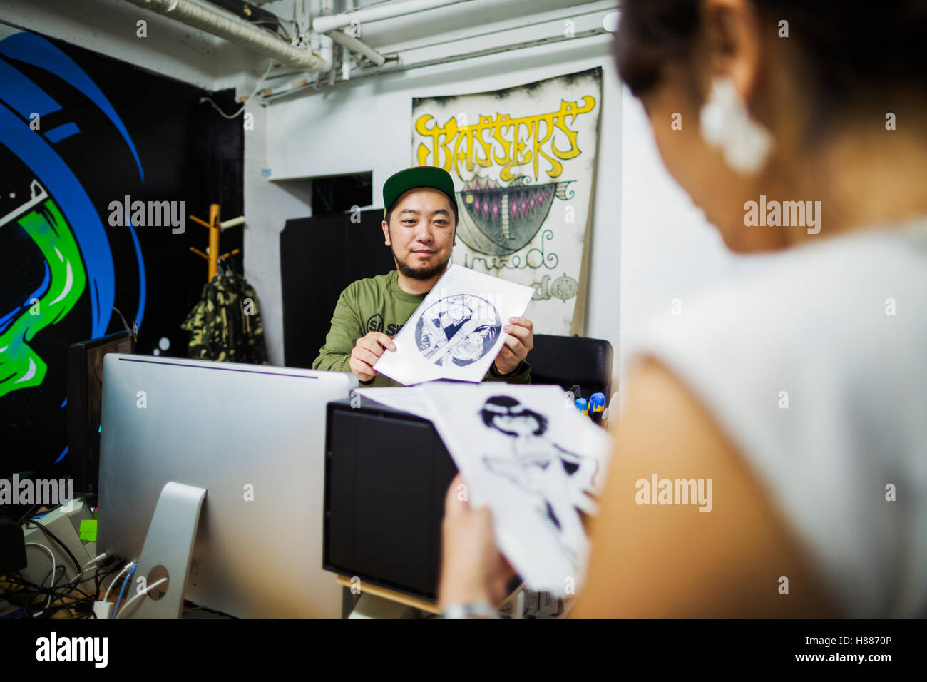 Due persone, designer lavora in una piccola azienda, guardando le illustrazioni. Foto Stock