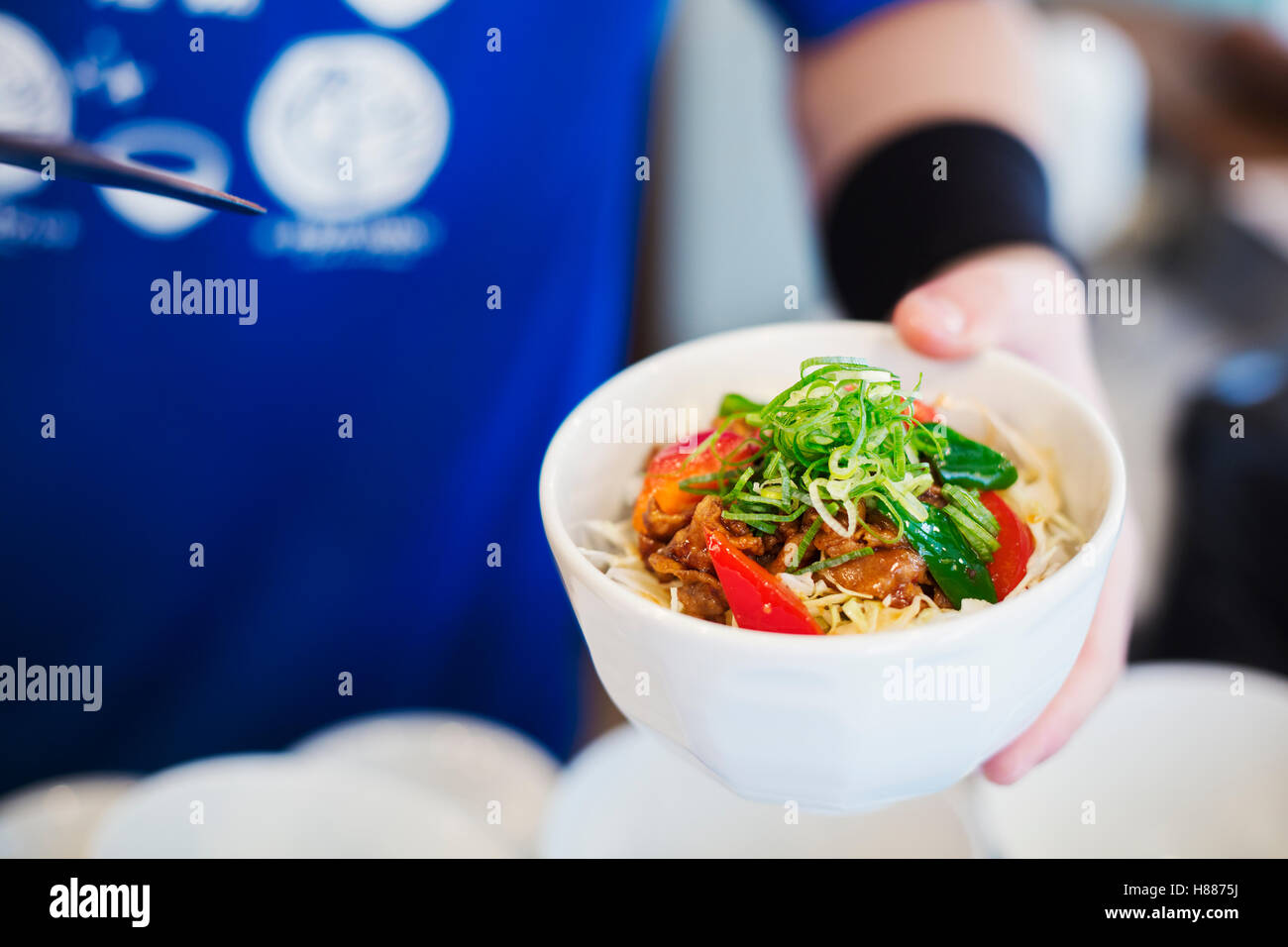 Il ramen noodle shop. Uno chef che prepara una ciotola di carni di spaghetti ramen con carne e verdure. Foto Stock